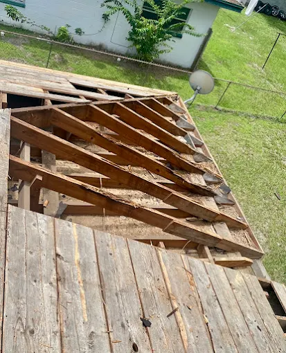 Exposed, storm-damaged roof rafters and decking on a Central Florida home